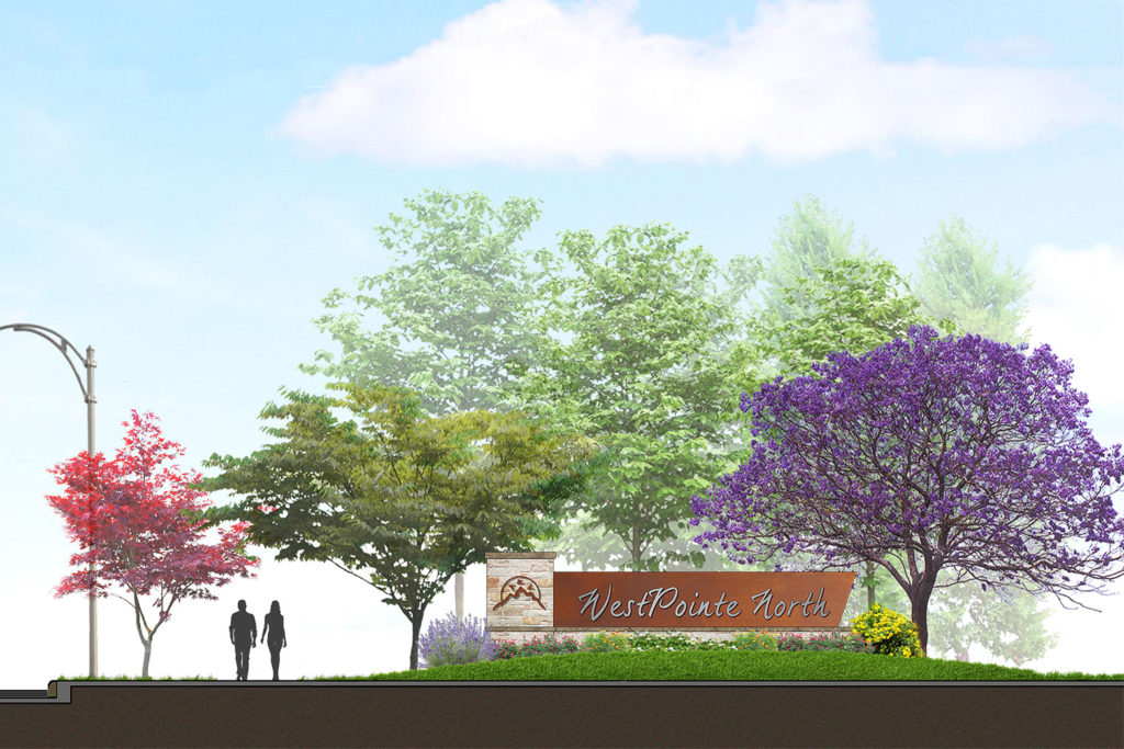 WesPointe North sign with stone column sitting in front of colorful trees and a shadow of a couple walking on the left