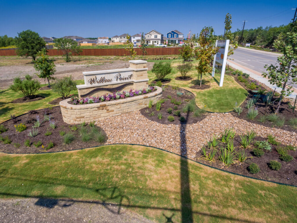 Subdivision entrance with landscaped grassy garden and white sign that reads Willow Point