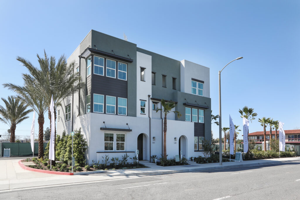 Modern three-story building flanked by palm trees under a clear blue sky in Jessup.