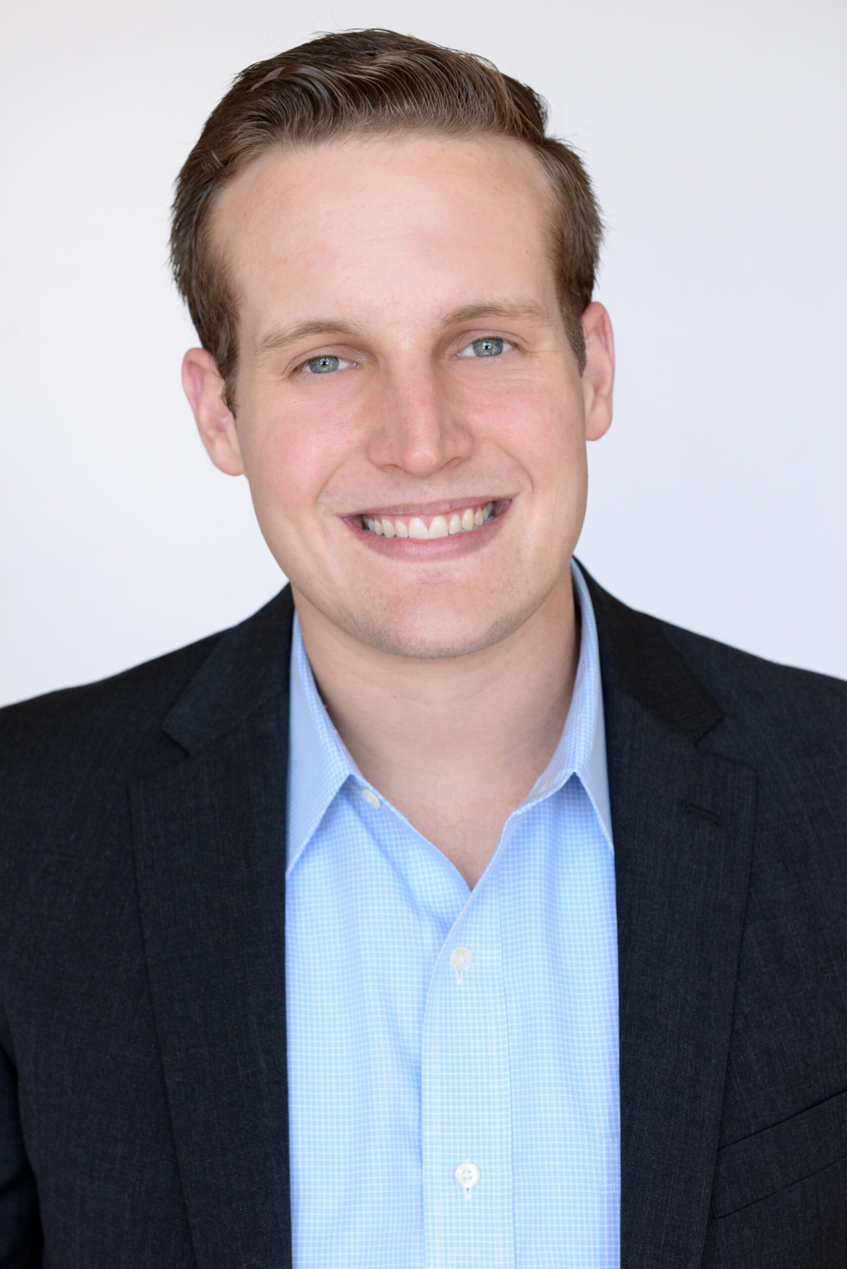 Brent Summers, a man in a suit and blue shirt, smiling.