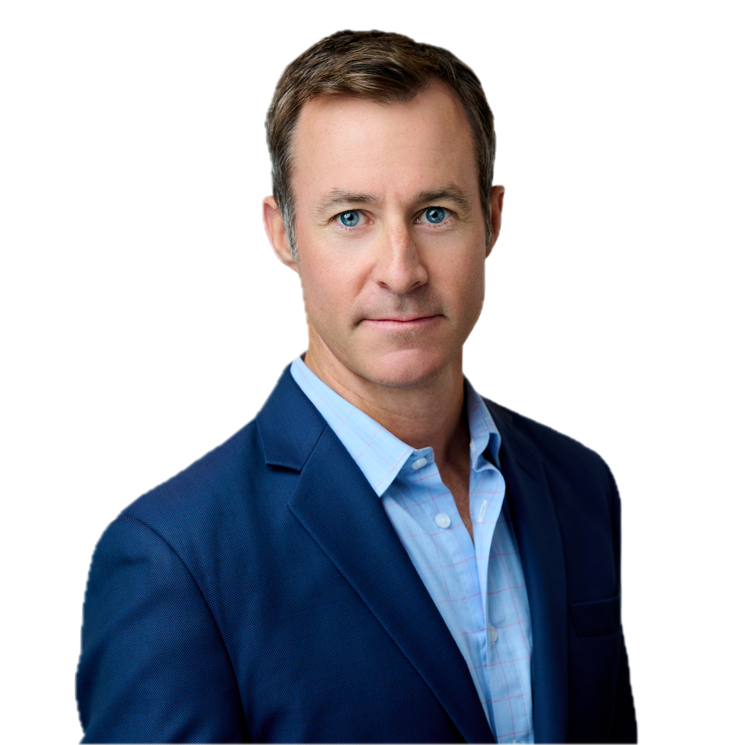 A man with short brown hair wearing a blue suit jacket and light blue shirt is facing forward against a plain white background.